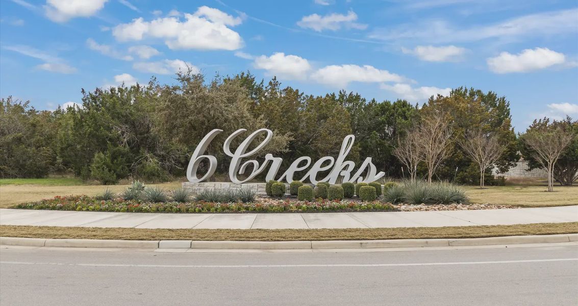 Entrance to the 6 Creeks community in Kyle, TX, featuring signage and landscaping (Image 2).