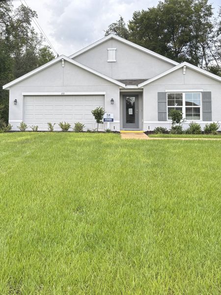 A modern gray home with shutters and a well-maintained lawn in Marion County Spot Lots by D.R. Horton (Ocala, FL).