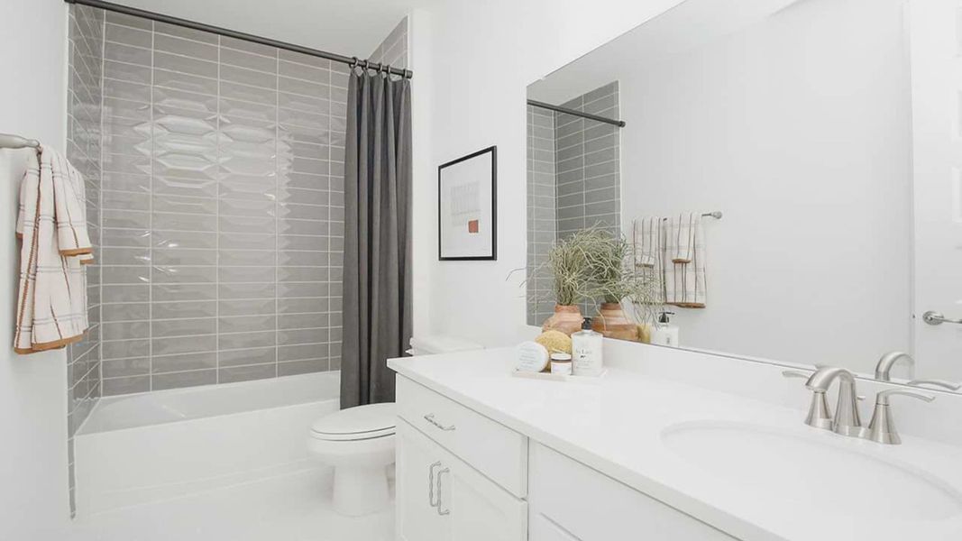 Luxurious bathroom features sleek white vanity, stylish gray tile, and premium fixtures in Cypress Green. Luxurious bathroom features sleek white vanity, stylish gray tile, and premium fixtures in Cypress Green.