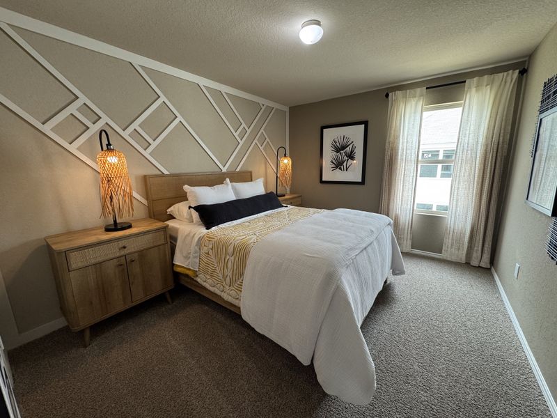 Cozy bedroom with geometric accent wall, warm lighting, and elegant décor.