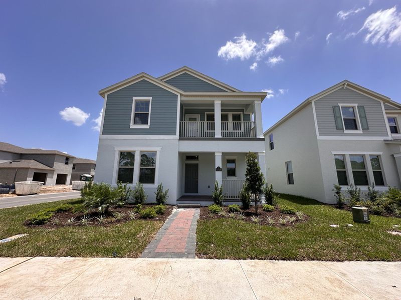 A charming two-story blue and white home with a landscaped yard in Waterleigh by D.R. Horton (Winter Garden, FL).