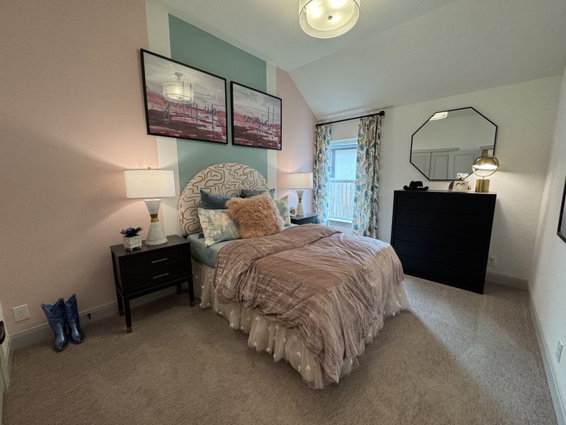 A cozy bedroom with elegant decor, featuring a plush bed, floral curtains, and modern lighting.