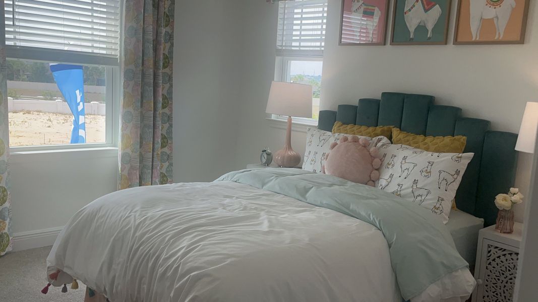 A cozy bedroom with a teal headboard, playful llama prints, and a soft pastel palette, creating a welcoming ambiance.