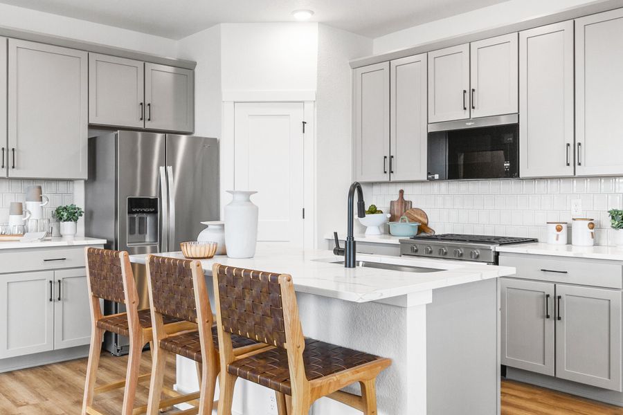 Elegant marble island and sleek gray cabinetry define this Falcon, Colorado kitchen.