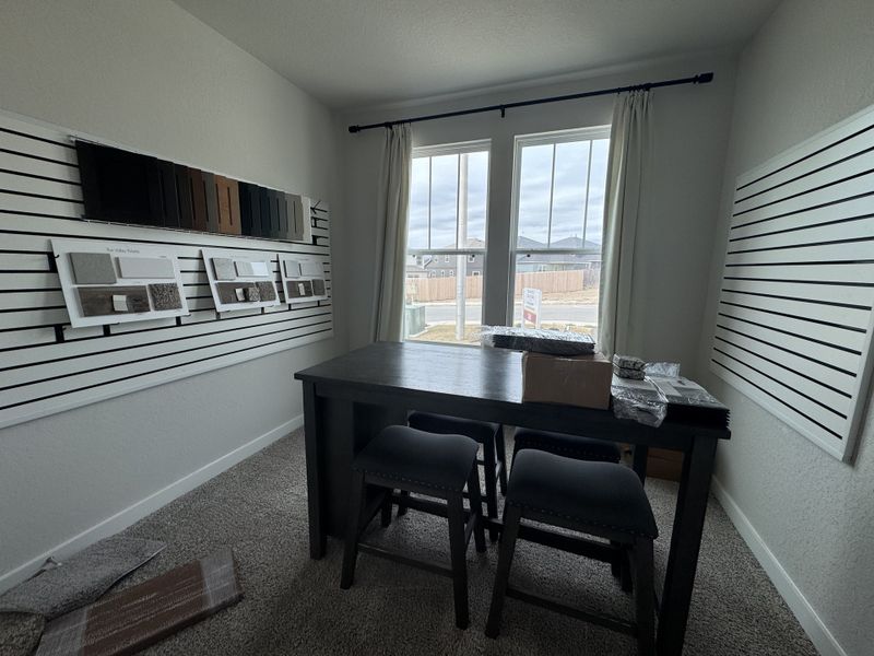 A modern design studio with sample boards, a sleek table, and tall windows providing ample natural light. A modern design studio with sample boards, a sleek table, and tall windows providing ample natural light.