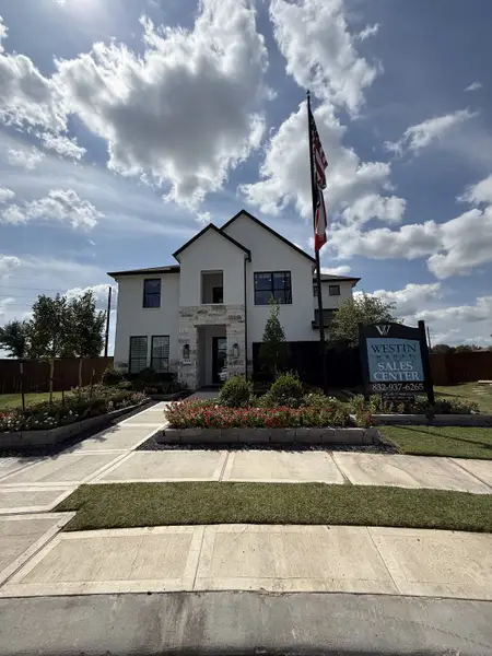 A modern white-brick home with elegant landscaping in Meridiana - 60' by Westin Homes (Manvel, TX).