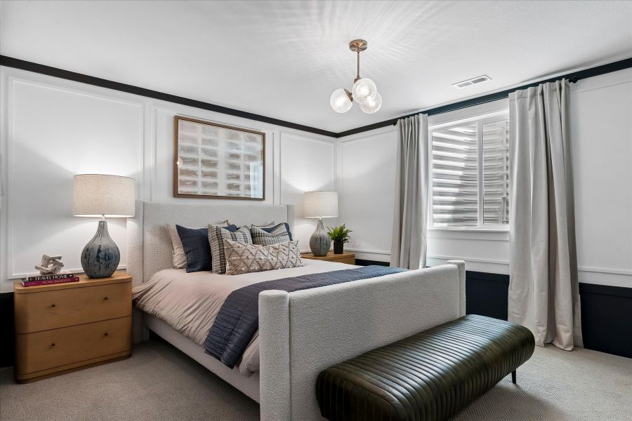 A bedroom with a bed and lamps.