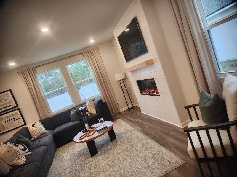 A cozy living room featuring a modern fireplace, plush sectional sofa, and soft lighting.