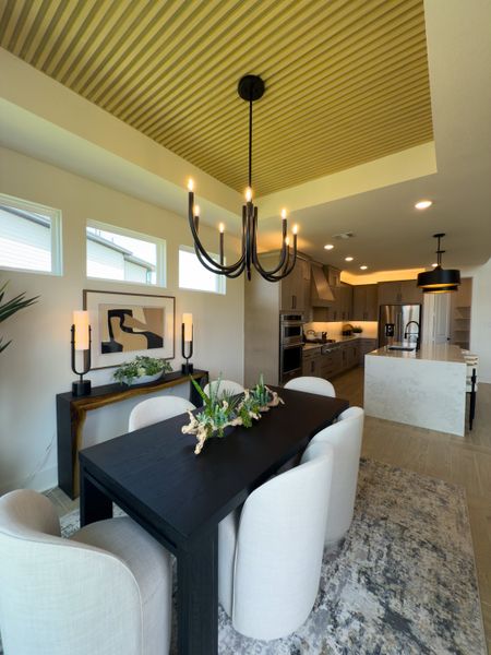 Elegant dining area with a sleek black table, modern chandelier, and stylish decor creating a contemporary ambiance. Elegant dining area with a sleek black table, modern chandelier, and stylish decor creating a contemporary ambiance.