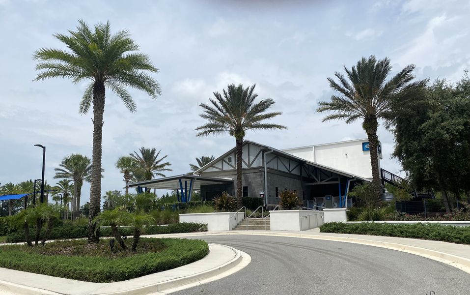 A modern community center with palm trees and landscaped greenery in Kettering at eTown by David Weekley Homes (Jacksonville, FL).