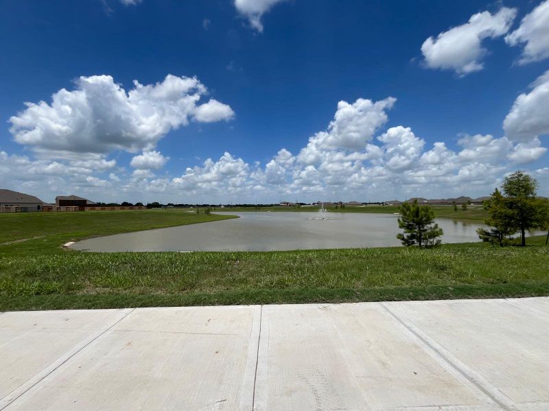 A scenic pond with lush greenery and a peaceful ambiance in Miller's Pond by M/I Homes (Rosenberg, TX).