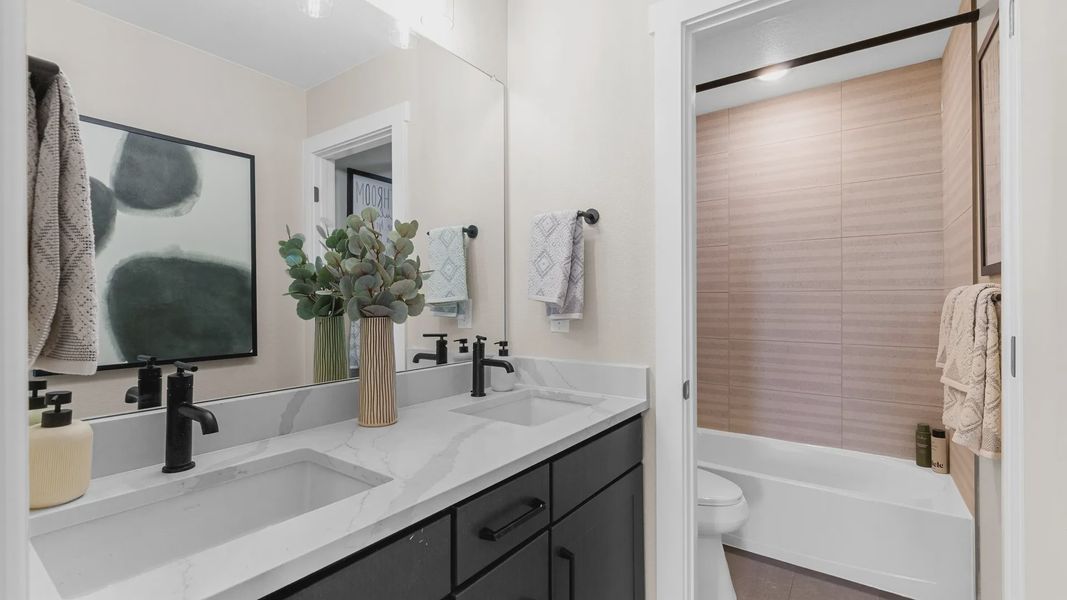 Exquisite bathroom features dual marble sinks, chic black fixtures, and sleek modern design, Timnath Lakes. Exquisite bathroom features dual marble sinks, chic black fixtures, and sleek modern design, Timnath Lakes.
