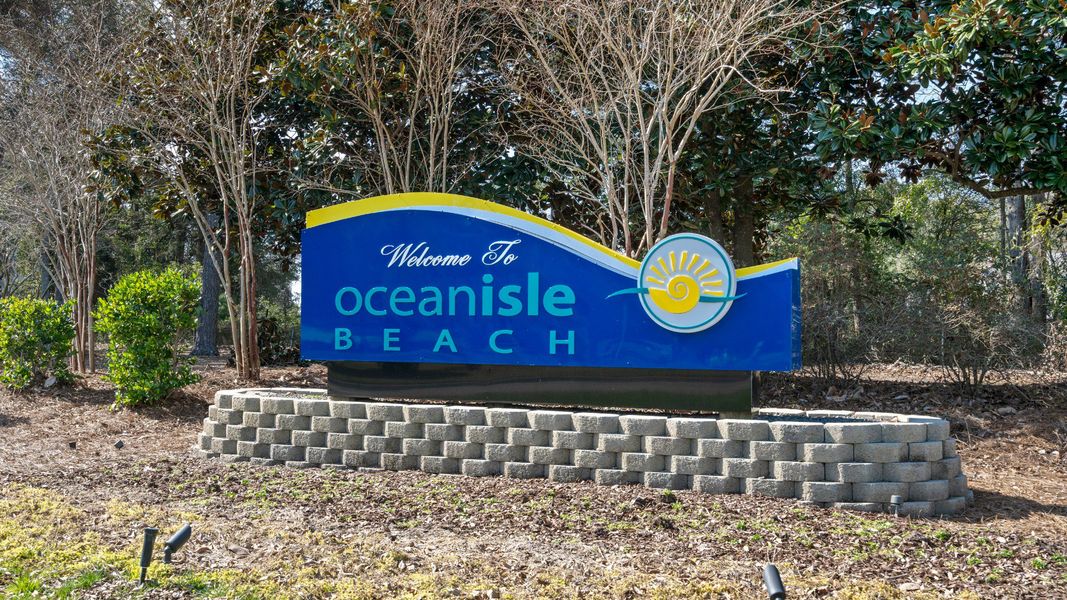 Entrance to the Courtyards by Carrell community in Ocean Isle Beach, NC, featuring signage and landscaping (Image 2). Entrance to the Courtyards by Carrell community in Ocean Isle Beach, NC, featuring signage and landscaping (Image 2).