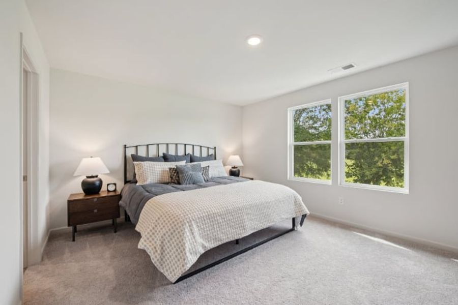 A bedroom with a bed and a window.