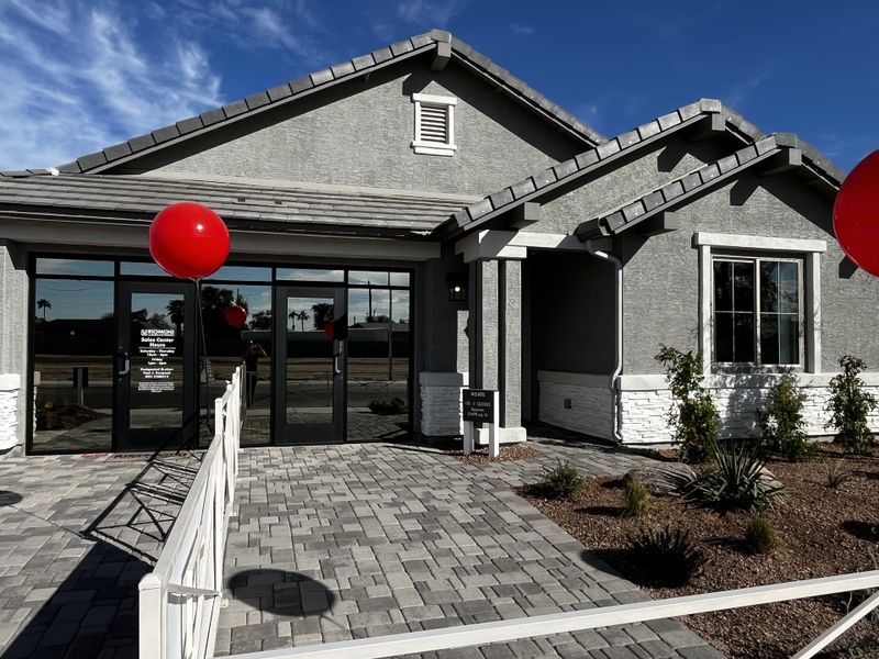 A stylish house with a light garage, stone accents, and and a paved driveway, set in a sunny neighborhood.