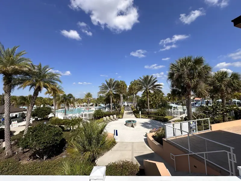 A tropical paradise pool area with palm trees and resort-style amenities in Solara Resort by Mattamy Homes (Kissimmee, FL).