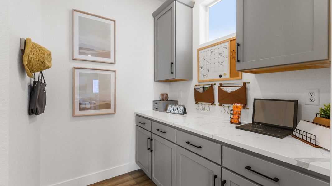 Elegant cabinetry and sleek quartz countertops elevate this luminous home office in Bloom community.