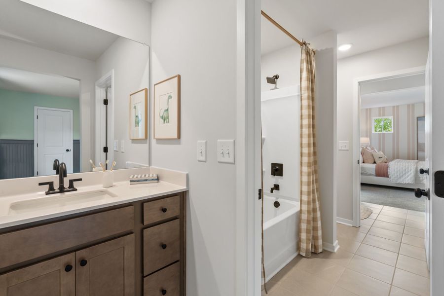 A bathroom with a sink and a bed.