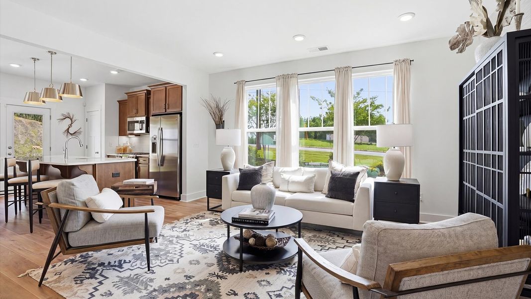 Elegant family room featuring hardwood flooring, large windows, and thoughtful architectural detail in Simpsonville, SC