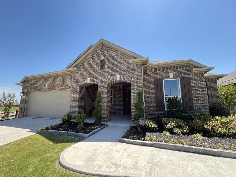 A beautiful brick home with elegant arches and lush landscaping in The Preserve by KB Home (Justin, TX). A beautiful brick home with elegant arches and lush landscaping in The Preserve by KB Home (Justin, TX).