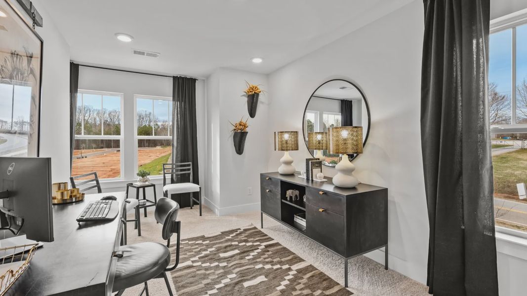 Study with plush carpet and large windows in two story townhome at Saluda Crossing by DRB Homes in Piedmont, SC