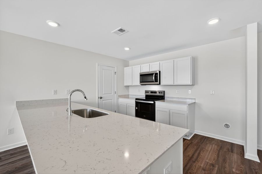 A kitchen with white cabinets.