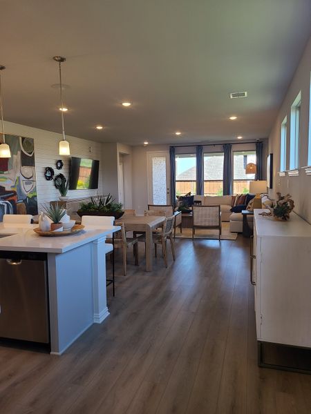 A modern living area with sleek hardwood floors, pendant lighting, and large windows offering abundant natural light. A modern living area with sleek hardwood floors, pendant lighting, and large windows offering abundant natural light.