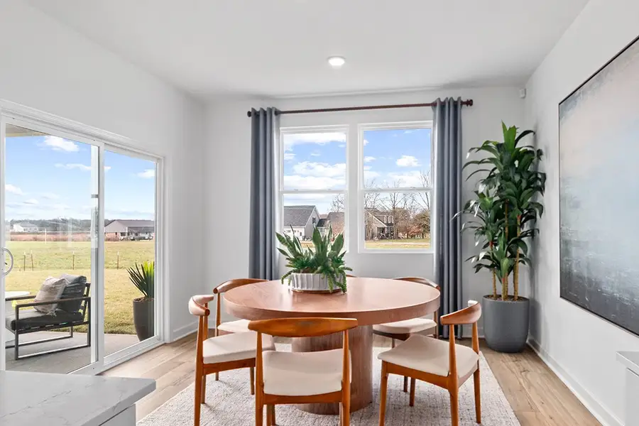 A table and chairs in a room with a window and a view of the water. A table and chairs in a room with a window and a view of the water.