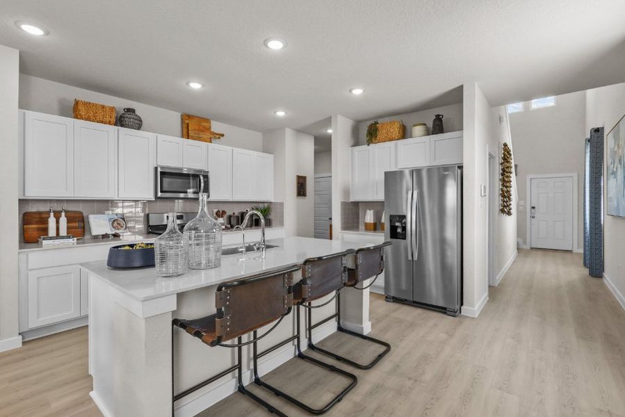 A kitchen with white cabinets.