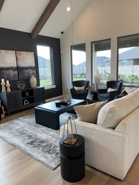 A chic living room with vaulted ceilings, exposed beams, modern furnishings, and large windows for natural light. A chic living room with vaulted ceilings, exposed beams, modern furnishings, and large windows for natural light.
