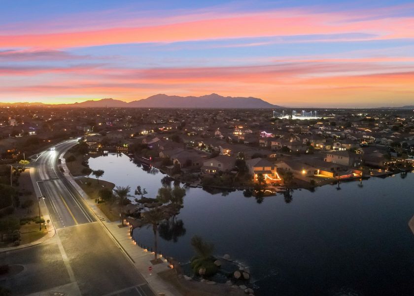 A road with a body of water and buildings along it.