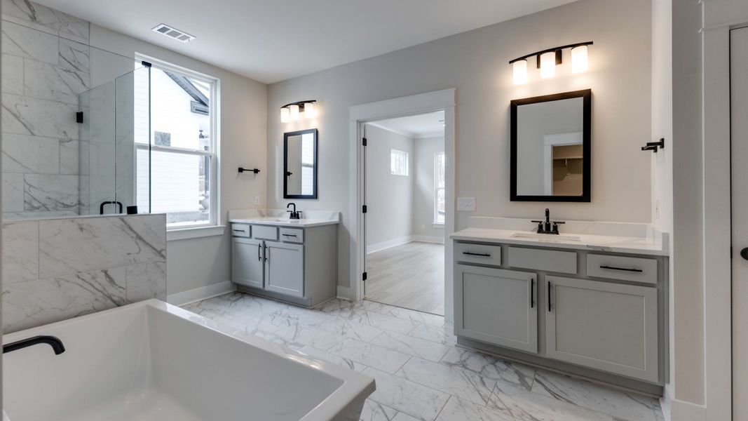 Bathroom with dual vanity, glass enclosed shower, and tub