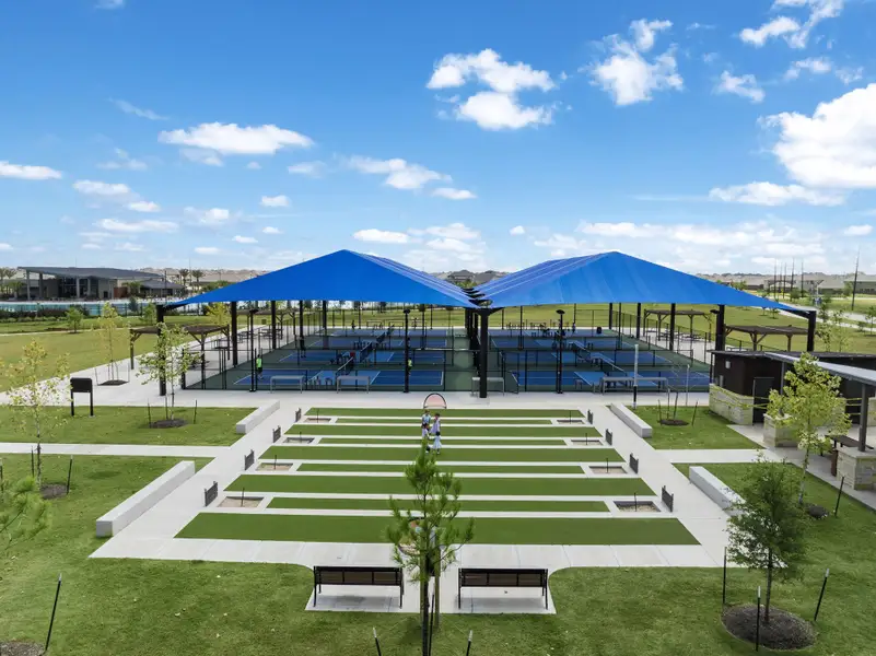 A large green field with a building in the background.