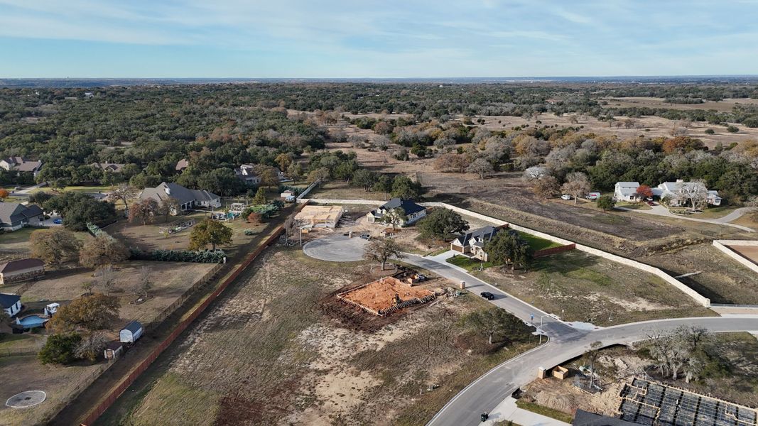 Aerial view of a developing neighborhood in Broken Oak by Highland Homes, showcasing spacious lots and natural surroundings (Georgetown, TX).