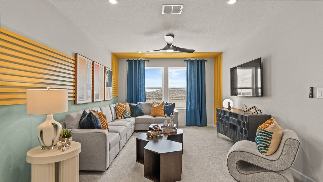 Relax in the upstairs of The Highbourne at Hamilton Bluff, featuring bold colors, cozy seating, and natural light.