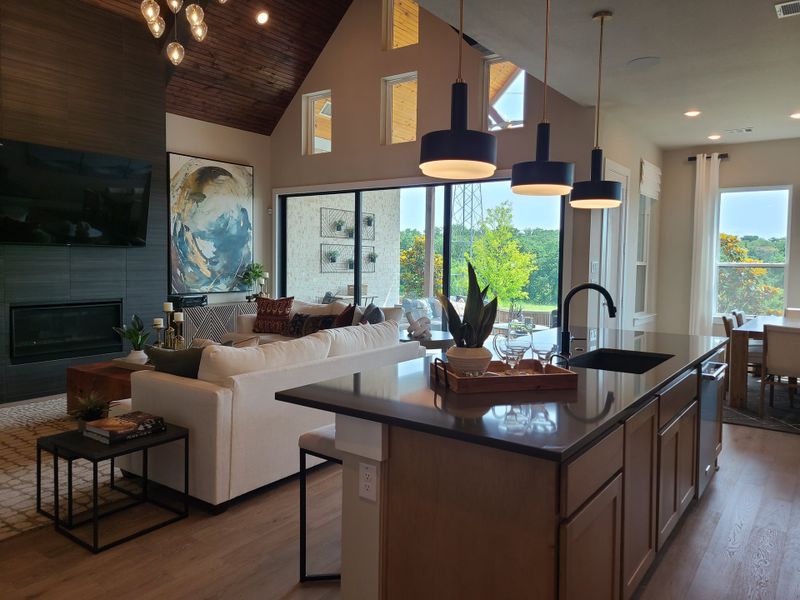 A modern living space with high ceilings, elegant pendant lights, large windows, and a stylish kitchen island. A modern living space with high ceilings, elegant pendant lights, large windows, and a stylish kitchen island.