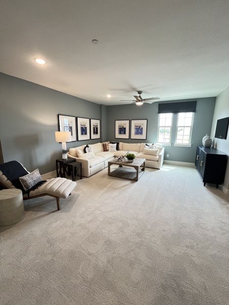 A contemporary living room with plush seating, a modern ceiling fan, and chic wall art. A contemporary living room with plush seating, a modern ceiling fan, and chic wall art.