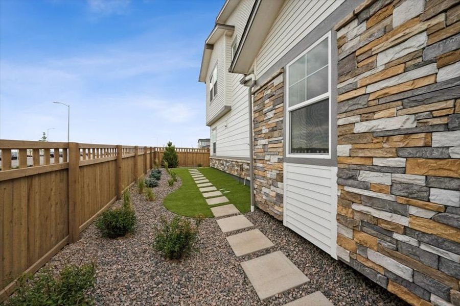 A stone wall next to a house. A stone wall next to a house.