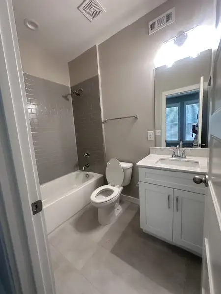 A modern bathroom featuring a sleek vanity, gray tile backsplash, and bright lighting for a polished look.