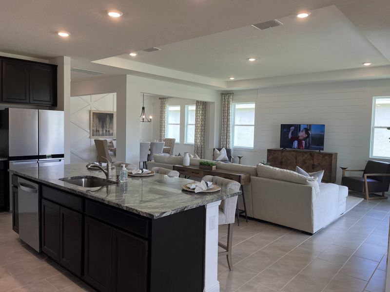 A spacious open-concept living area with a modern kitchen, cozy seating, and elegant lighting. A spacious open-concept living area with a modern kitchen, cozy seating, and elegant lighting.