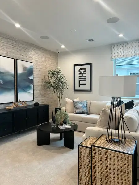 A modern living room with cozy seating, abstract art, soft lighting, and stylish decor for a relaxing ambiance.