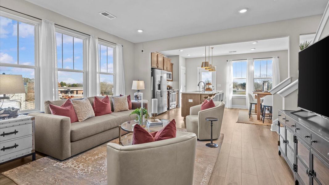 Elegant family room featuring hardwood flooring, large windows, and thoughtful architectural detail at Anna's Pointe Elegant family room featuring hardwood flooring, large windows, and thoughtful architectural detail at Anna's Pointe