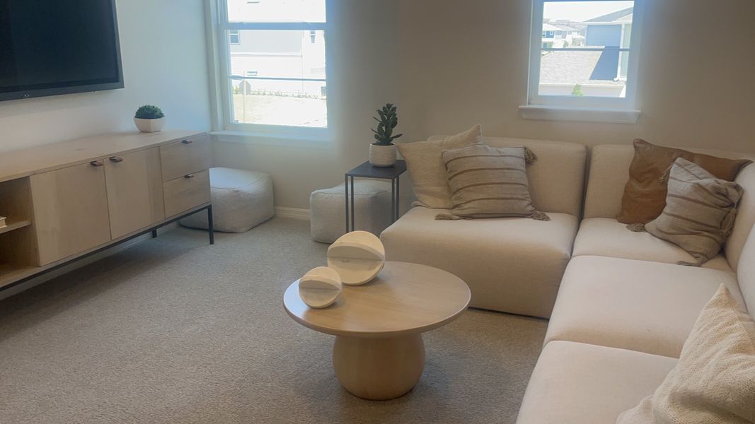 A cozy living room featuring a sleek beige sectional, modern decor, and abundant natural light from large windows. A cozy living room featuring a sleek beige sectional, modern decor, and abundant natural light from large windows.