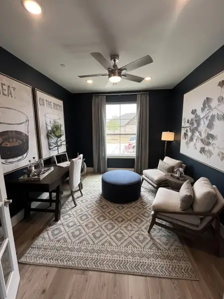 A cozy study room with dark walls, a stylish rug, and a sleek desk, complemented by contemporary seating and artwork. A cozy study room with dark walls, a stylish rug, and a sleek desk, complemented by contemporary seating and artwork.