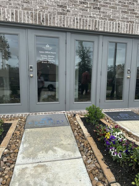 Elegant office entrance with gray double doors and vibrant flowerbeds in Lakes at Black Oak by Century Communities (Magnolia, TX). Elegant office entrance with gray double doors and vibrant flowerbeds in Lakes at Black Oak by Century Communities (Magnolia, TX).