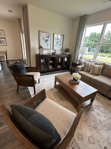 A cozy living room with elegant decor, featuring a wooden coffee table, plush seating, and bright natural light.