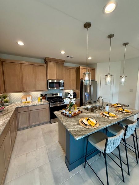 A modern kitchen with wood cabinetry, granite countertops, a sleek island, and elegant pendant lighting. A modern kitchen with wood cabinetry, granite countertops, a sleek island, and elegant pendant lighting.