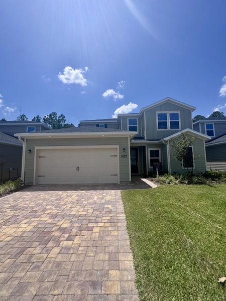 A modern two-story home with a paved driveway and manicured lawn in Russell Retreat by Lennar (Green Cove Springs, FL).