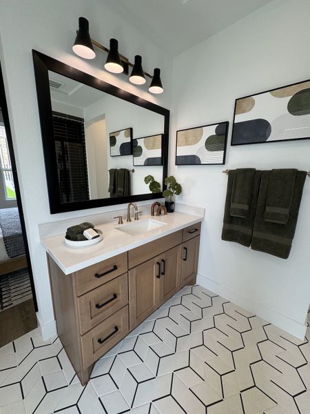 A modern bathroom with geometric tiles, a chic wooden vanity, and stylish lighting. A modern bathroom with geometric tiles, a chic wooden vanity, and stylish lighting.