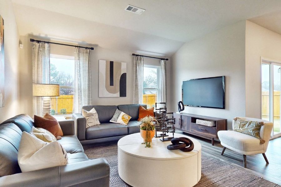 A living room with a tv and couches. A living room with a tv and couches.